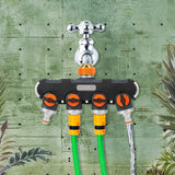 A 4-way garden tap manifold attached to an outdoor brass tap with irrigation timers and garden hoses connected.