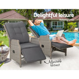 Two grey wicker recliner chairs by a swimming pool, one with a man relaxing with the footrest raised