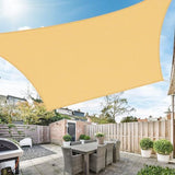Rectangular sun shade sail providing shade over an outdoor patio dining area