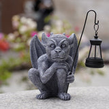 Solar-powered gargoyle statue holding an LED lantern with stone-like resin detailing